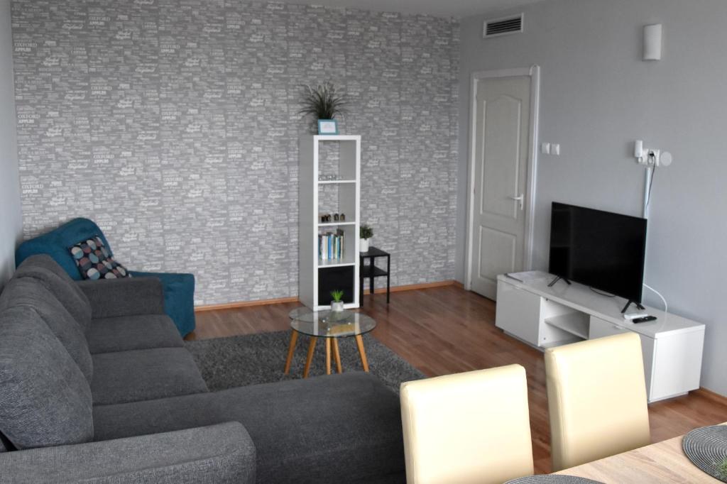 a living room with a couch and a tv at Panorama View Apartment in Veszprém