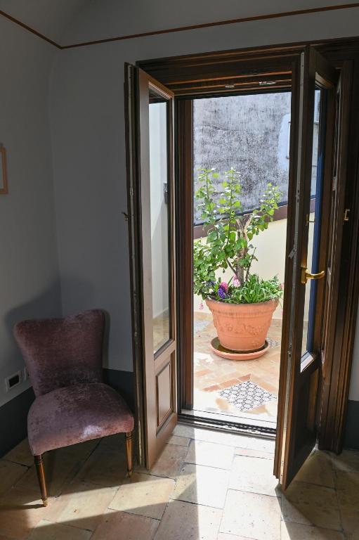an open door with a chair and a potted plant at Rachel's House in Altamura