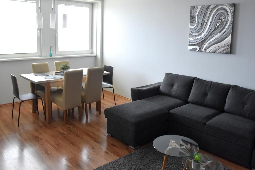 een woonkamer met een bank en een tafel bij Panorama View Apartment in Veszprém