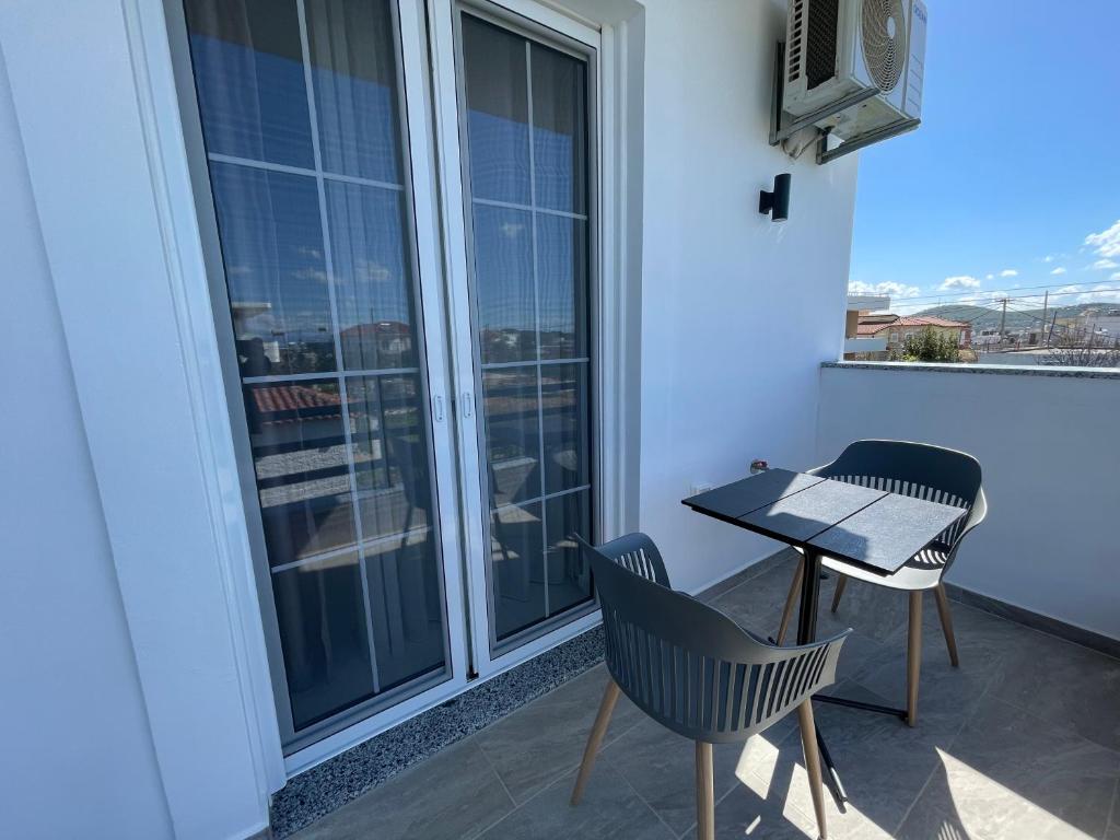 a balcony with a table and chairs and a window at Villa Denis Ksamil in Ksamil