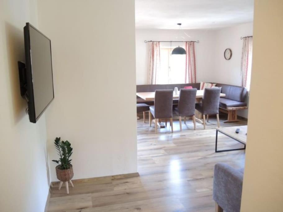 ein Wohnzimmer mit einem Tisch, Stühlen und einem TV in der Unterkunft Ferienwohnung Ochsenhorn in Lofer 100 m² / 4-8 P. in Lofer