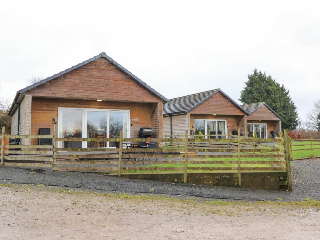 a house with a wooden fence in front of it at Holly Lodge in Preston