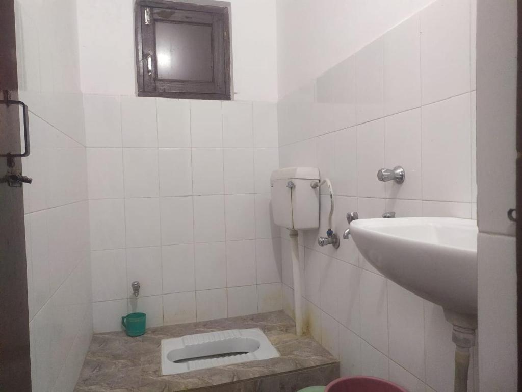 baño con lavabo y aseo en el suelo en Shree Radha Krishna Guest House By WB Inn en Harchandpur
