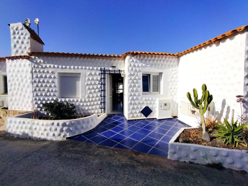 Biały dom z niebieskim, wyłożonym kafelkami podjazdem w obiekcie Vega Powered by SolymarCalma w mieście Costa Calma