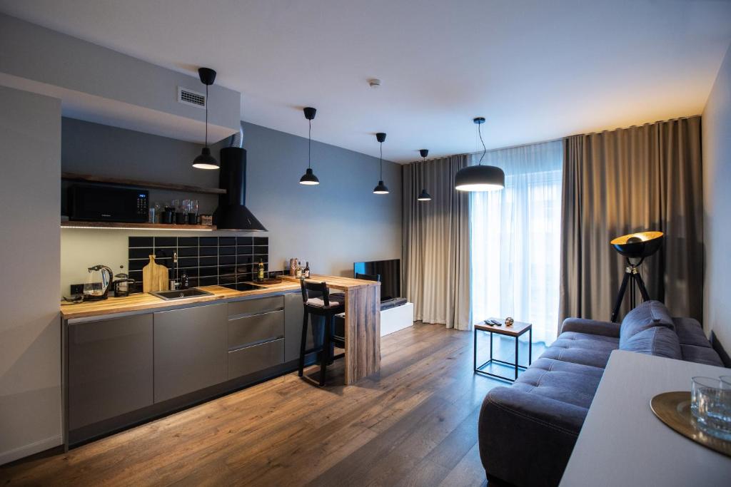 ein Wohnzimmer mit einem Sofa und einer Küche in der Unterkunft Revalia Das Haus Studios in Tallinn