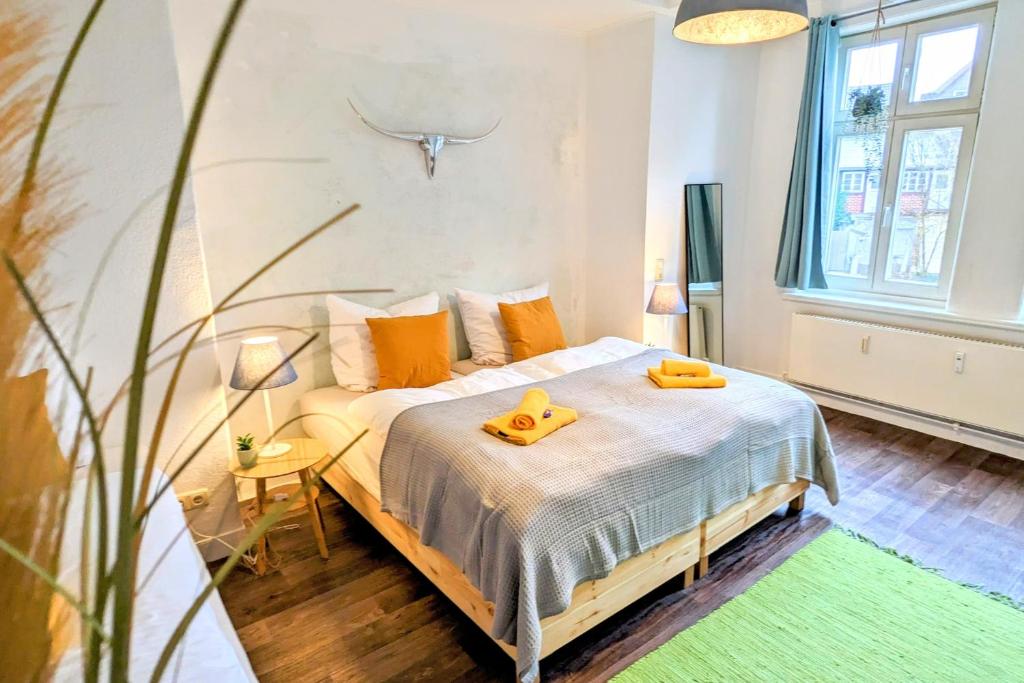 een slaapkamer met een bed met twee gele schoenen erop bij Uhlpartment - im Herzen von Uelzen in Uelzen