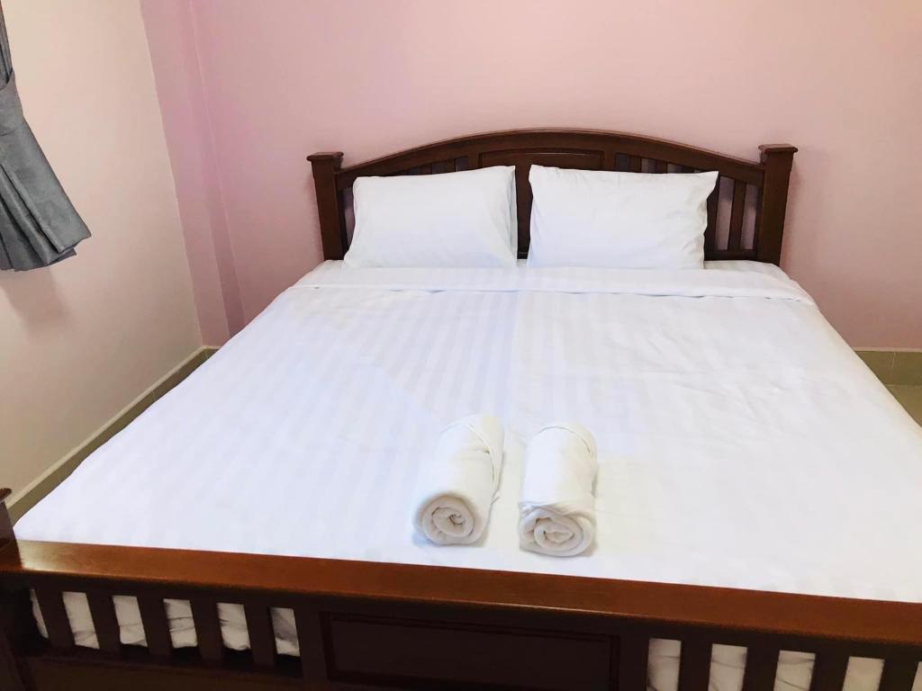 een bed met twee opgerolde handdoeken erop bij โรงแรม เทวาแกรนด์ รีสอร์ท กุฉินารายณ์ กาฬสินธุ์ in Ban Na Ko