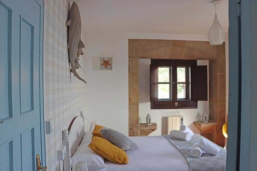 a bedroom with a large bed with yellow pillows at AL SON DE LAS OLAS in Lastres
