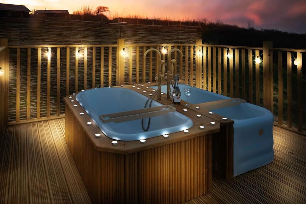 bañera azul en una terraza con luces en Troney Valley Escapes - Owl's Den en Crediton