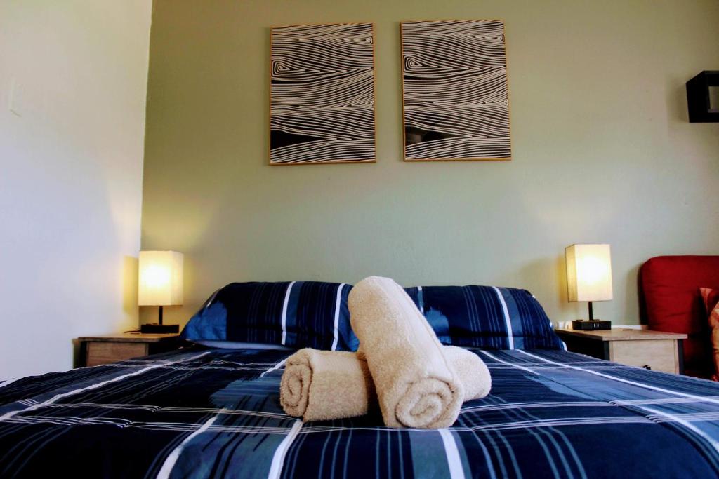 ein Schlafzimmer mit einem blauen und weißen Bett mit Handtüchern in der Unterkunft Marilou Apt A in Levittown