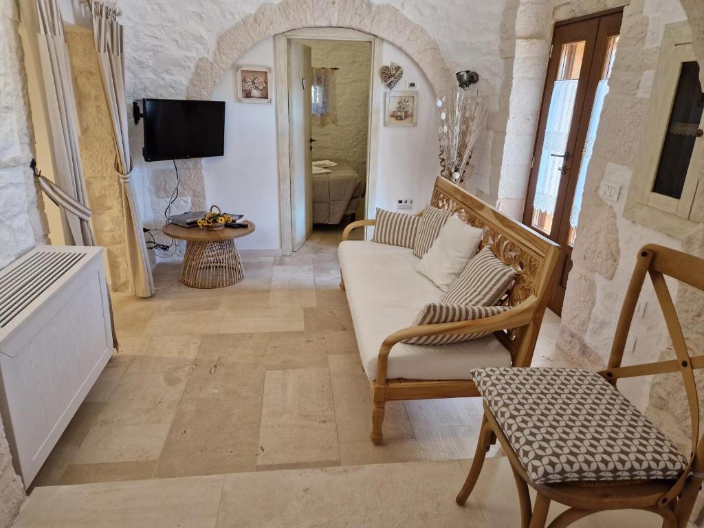 un salon avec un canapé et une chaise dans l'établissement Trullo Siamese, à Alberobello