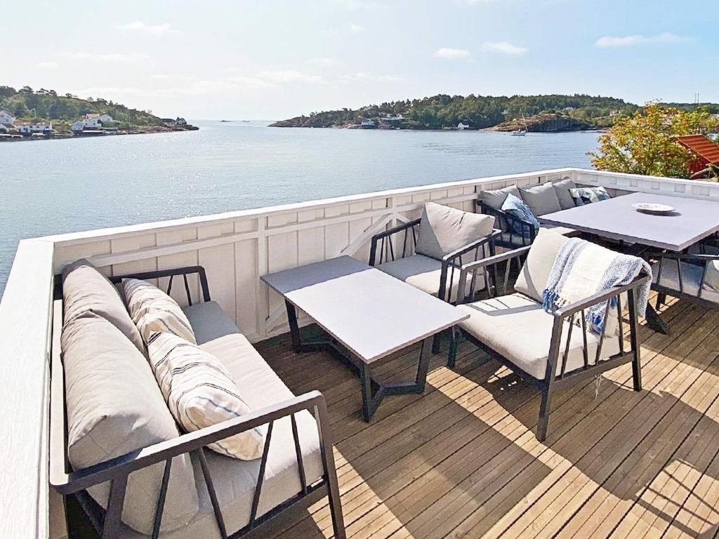 um deque de um barco com mesas e cadeiras em Holiday home LYNGØR 