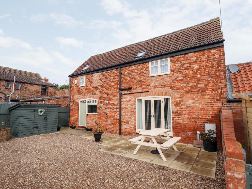 a brick house with a patio in front of it at Holly Barn in Hull