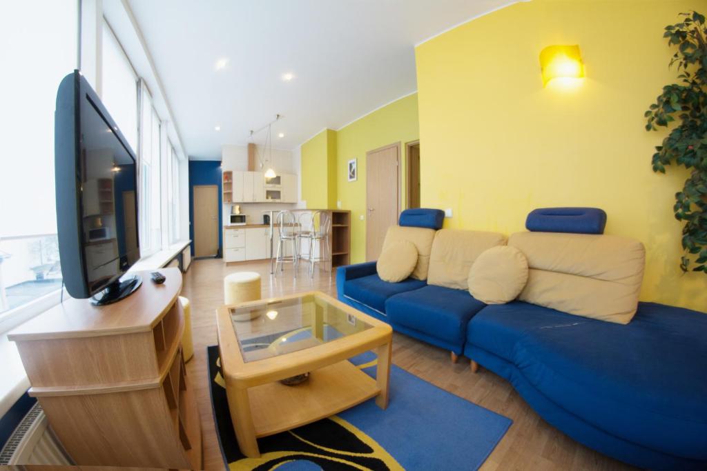 a living room with a blue couch and a tv at Laisves alley 50 in Kaunas