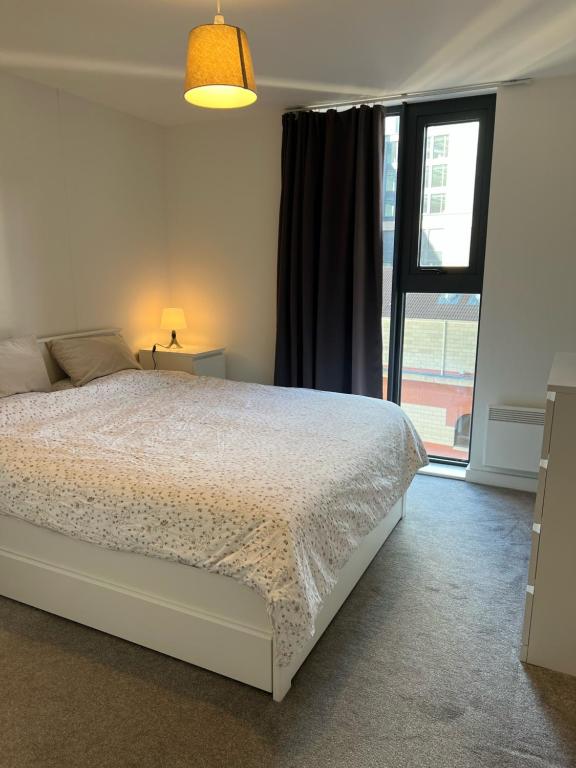 a bedroom with a bed and a large window at Brand new heart of Birmingham one bedroom in Birmingham