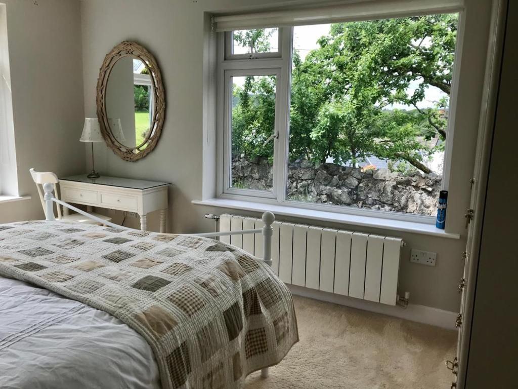 una camera con letto, specchio e finestra di Phoenix Cottage a Kippford