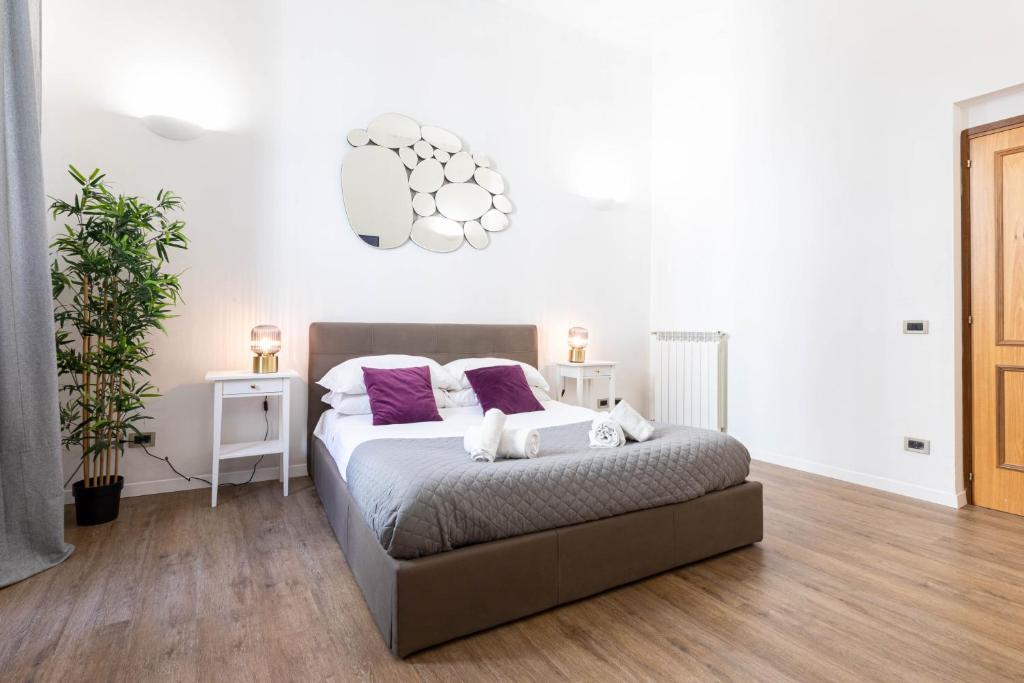 1 dormitorio con 1 cama con almohadas moradas en Toniolo Two Bedroom Two Bath, en Roma