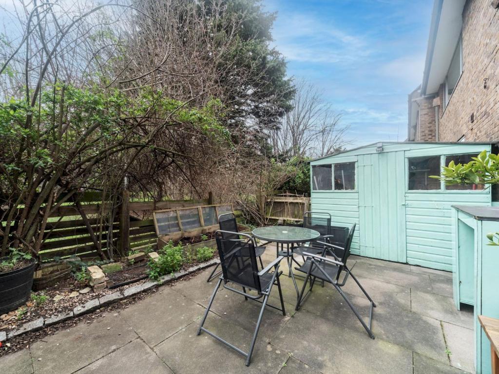 a patio with a table and chairs and a shed at Pass the Keys - Cosy Maisonette with Garden in Central East London in London