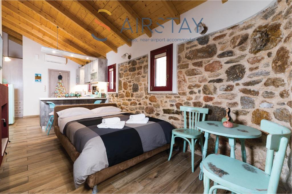a bedroom with a bed and a stone wall at Orianna Apartment Airport by Airstay in Spata