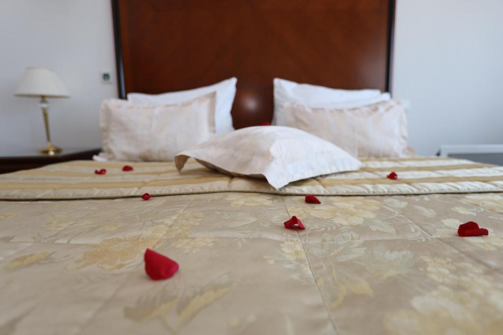 a bed with red rose petals on it at Apart-hotel Integra in Banja Luka