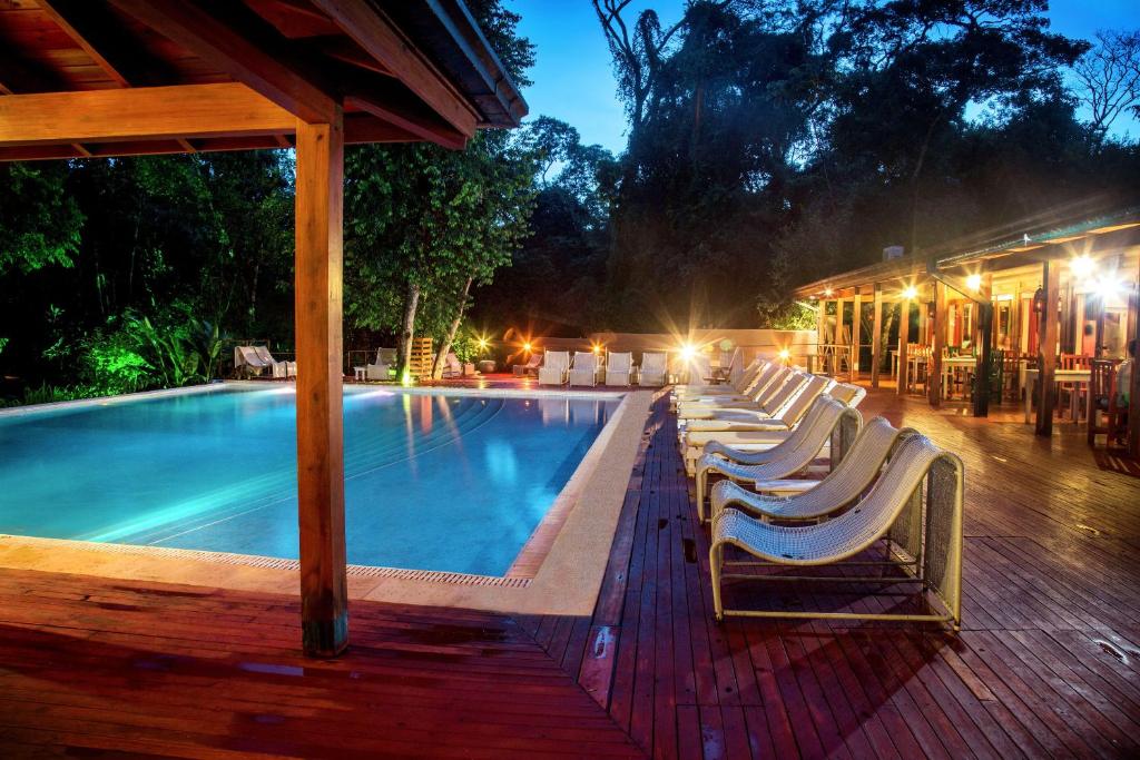 
a pool with chairs and tables in it at La Cantera Lodge de Selva in Puerto Iguazú
