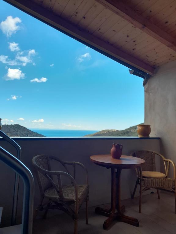 d'une table et de chaises sur un balcon avec vue sur l'océan. dans l'établissement Casa Luci, vista mare, à Vezzi Portio