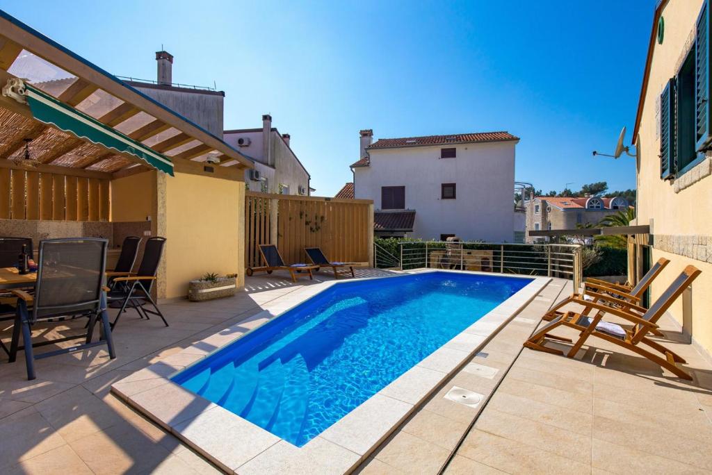 einen Pool auf einer Terrasse mit Stühlen und einem Tisch in der Unterkunft Villa Ivona with heated pool in Rovinj in Rovinj