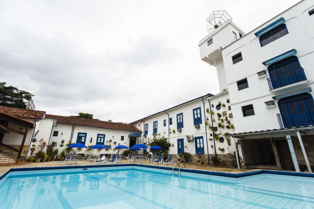 um hotel com piscina em frente a um edifício em VOA Hotel Caxambu em Caxambu