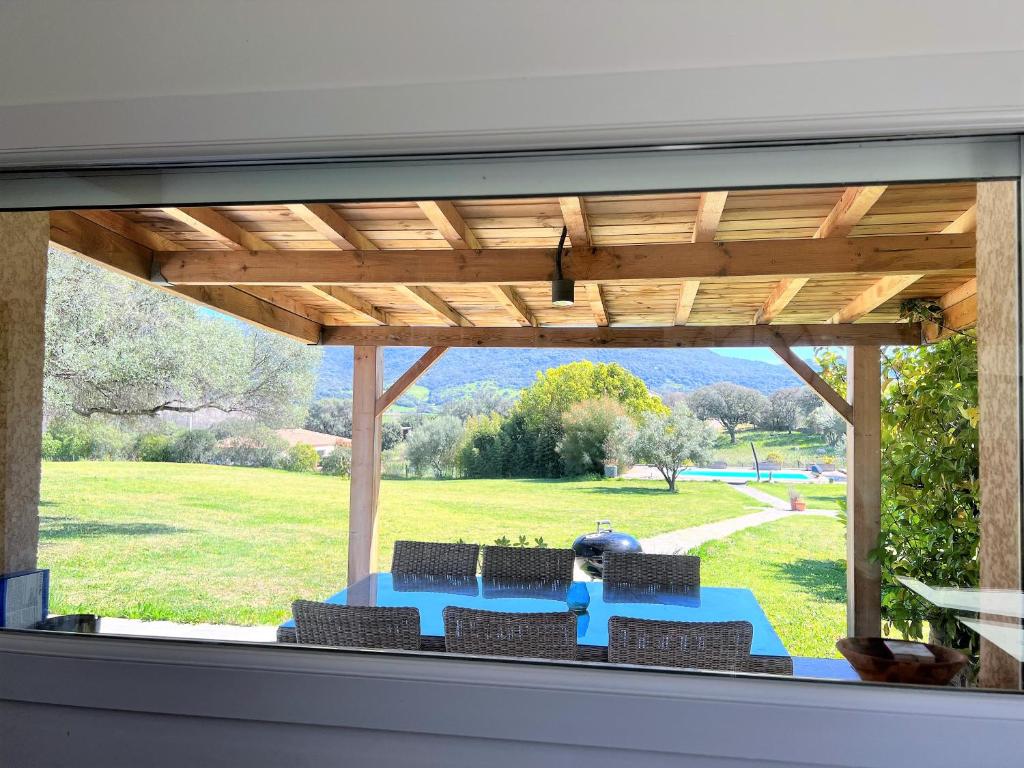 un patio con una mesa azul y algunas sillas en La villa Thomas avec piscine chauffée, classée 4 étoiles, en Serra-di-Ferro
