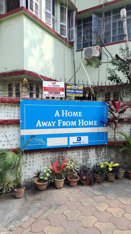 a home away from home sign on a wall with plants at A home away from home in Kolkata