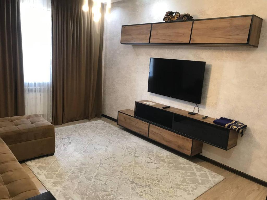 ein Wohnzimmer mit einem Flachbild-TV an der Wand in der Unterkunft Sergeli 9 Resedens in Taschkent