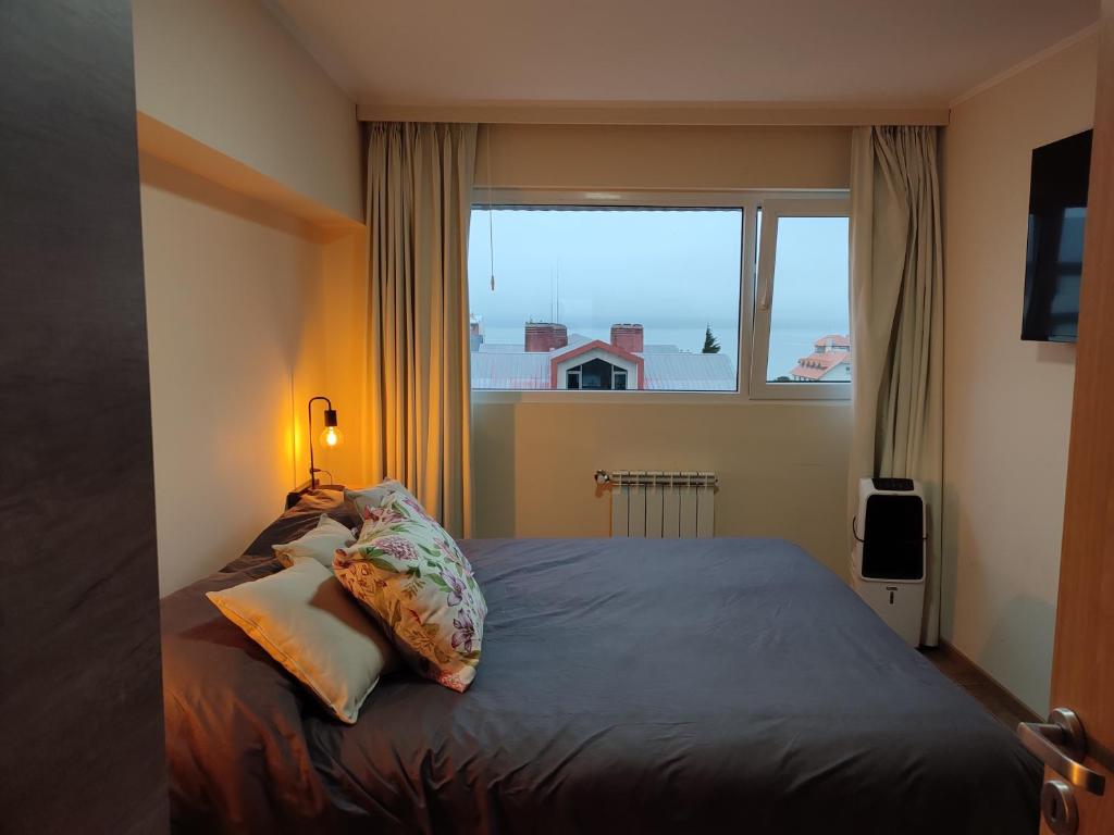 um quarto com uma cama e uma janela grande em Lofts Patagonia Mitre 3 em San Carlos de Bariloche