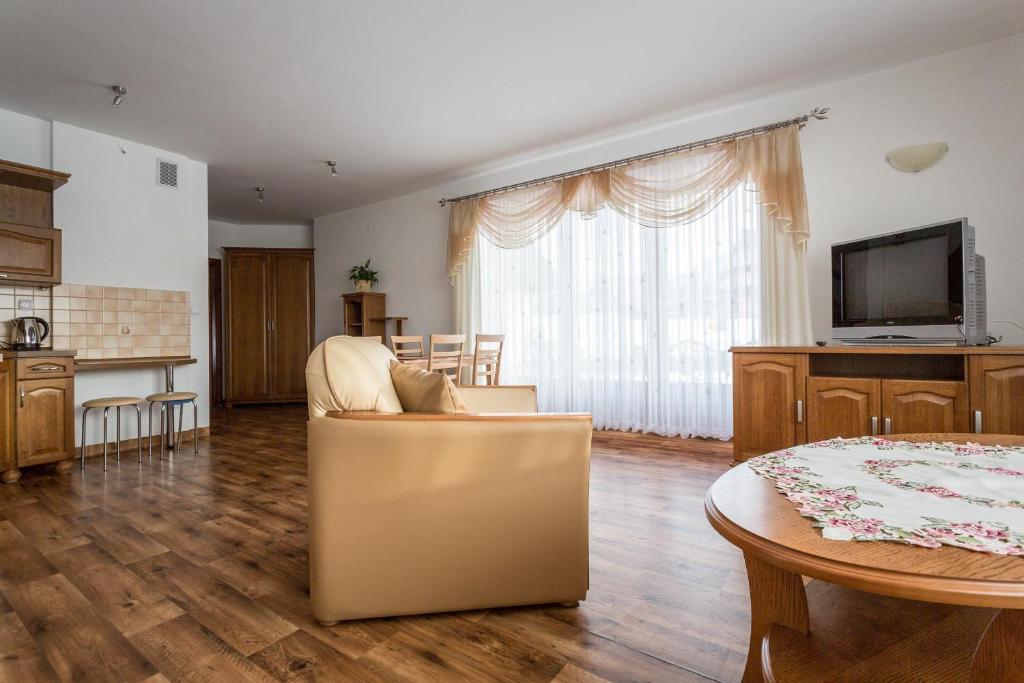 Televízia a/alebo spoločenská miestnosť v ubytovaní Sykowny Dworek Apartamenty