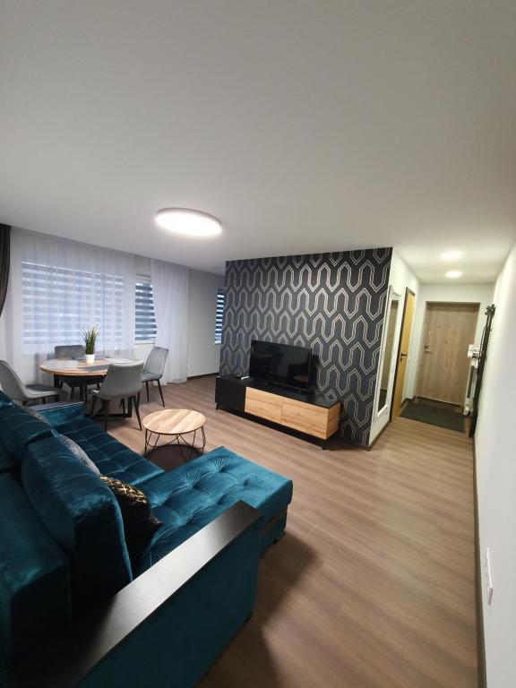 uma sala de estar com um sofá azul e uma televisão em City apartment 2 bedrooms em Siauliai