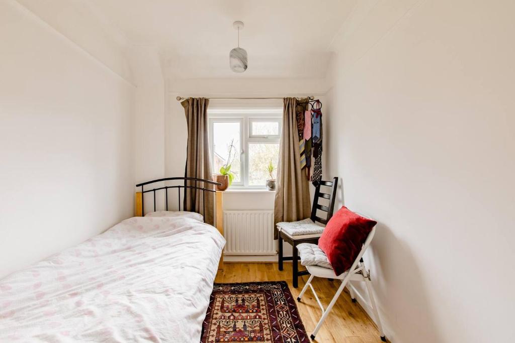 a bedroom with a bed and a chair and a window at Littlehaven in Roffey