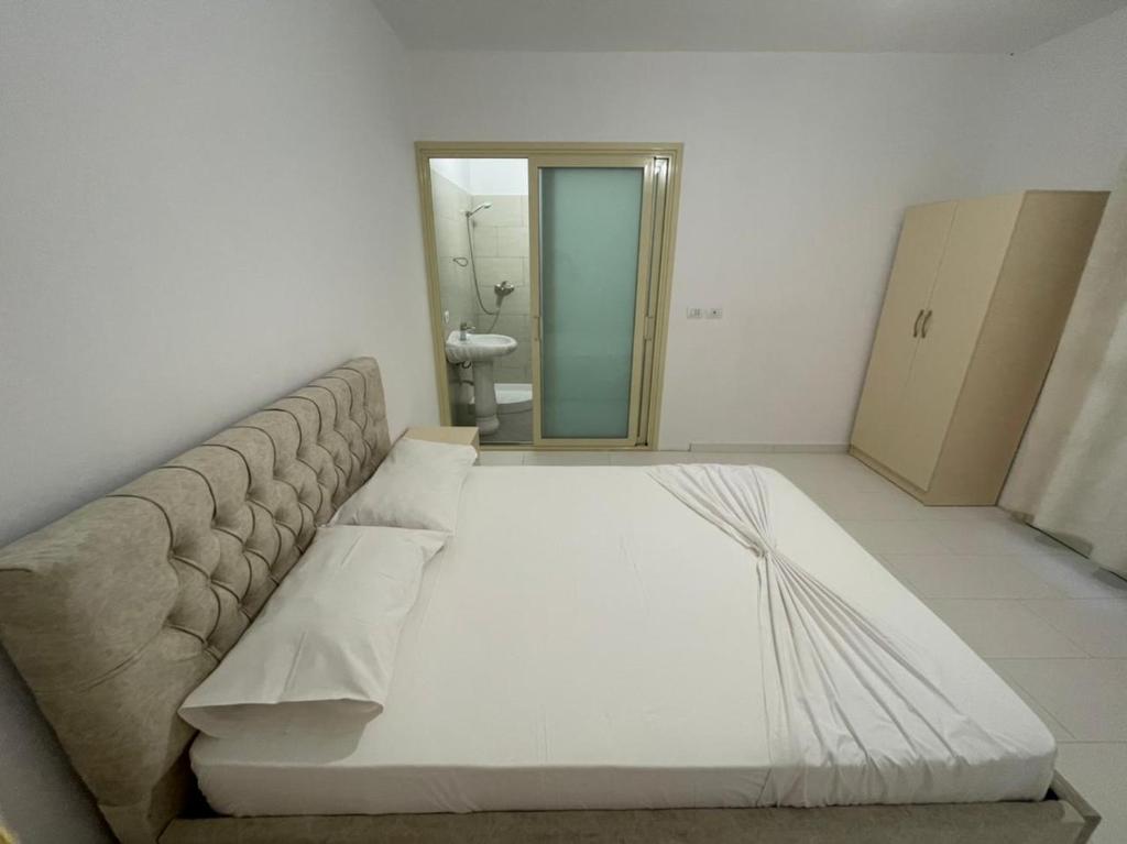 a large white couch in a room with a bathroom at Marios Rooms in Vlorë