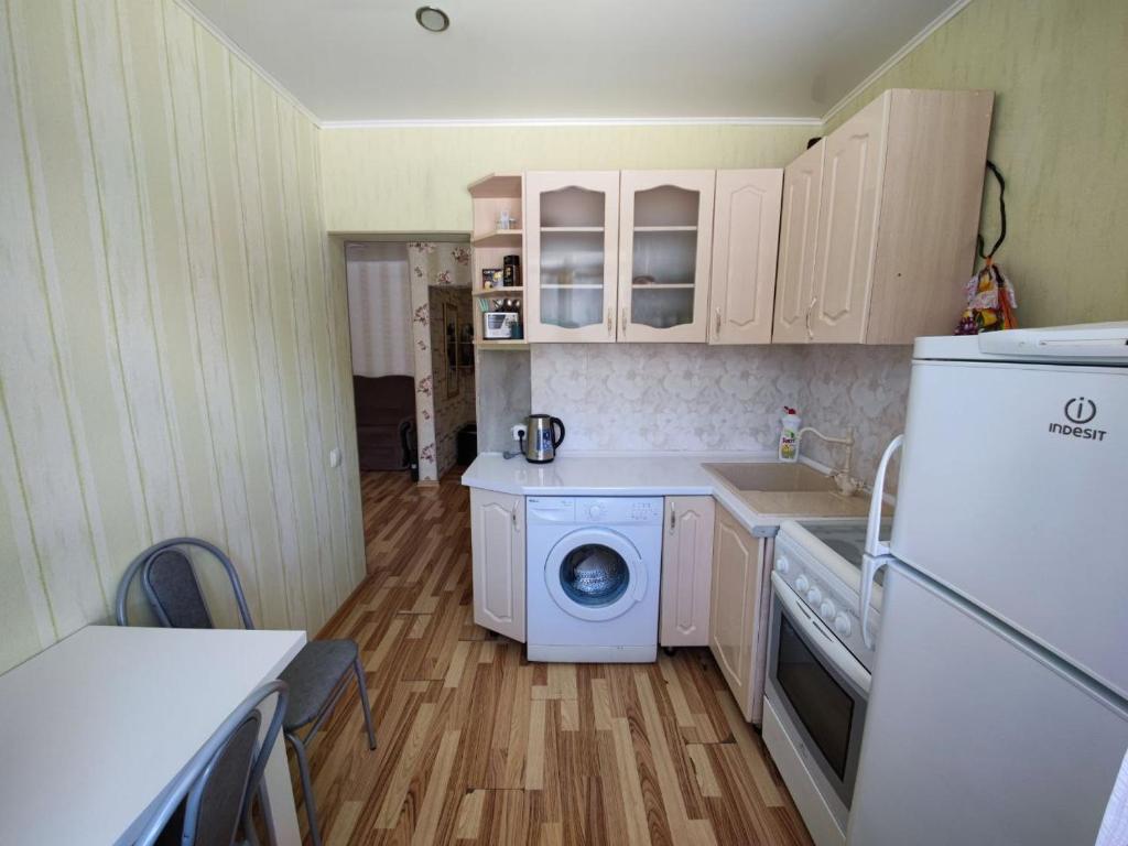 una pequeña cocina con lavadora y lavavajillas en Квартира посуточно, en Shchūchīnsk