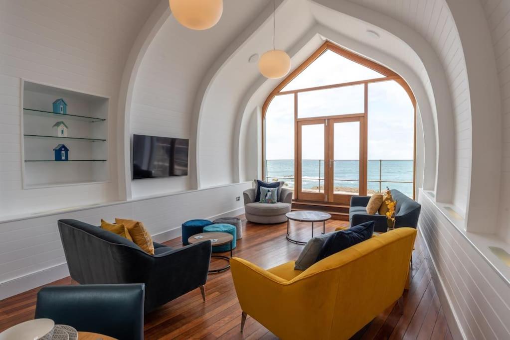 een woonkamer met stoelen en een groot raam bij Ultimate Harbourside in Ilfracombe