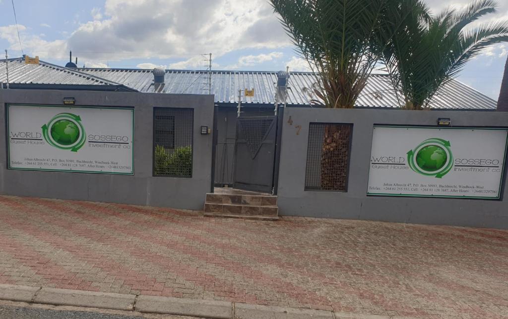 a building with green signs on the side of it at World Sossego Guest House in Windhoek