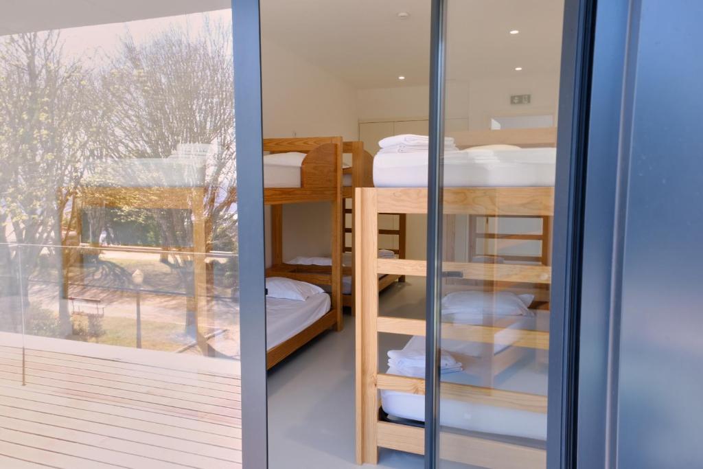 Pokój z łóżkami piętrowymi i przesuwnymi szklanymi drzwiami w obiekcie Albergue de Santa Luzia w mieście Viana do Castelo