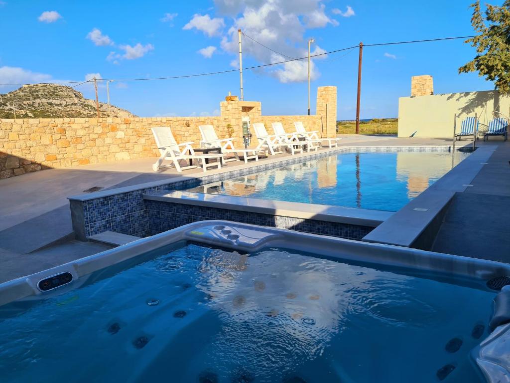 - une piscine avec des chaises dans l'eau dans l'établissement Elegant Villa Traounou, à Afantou