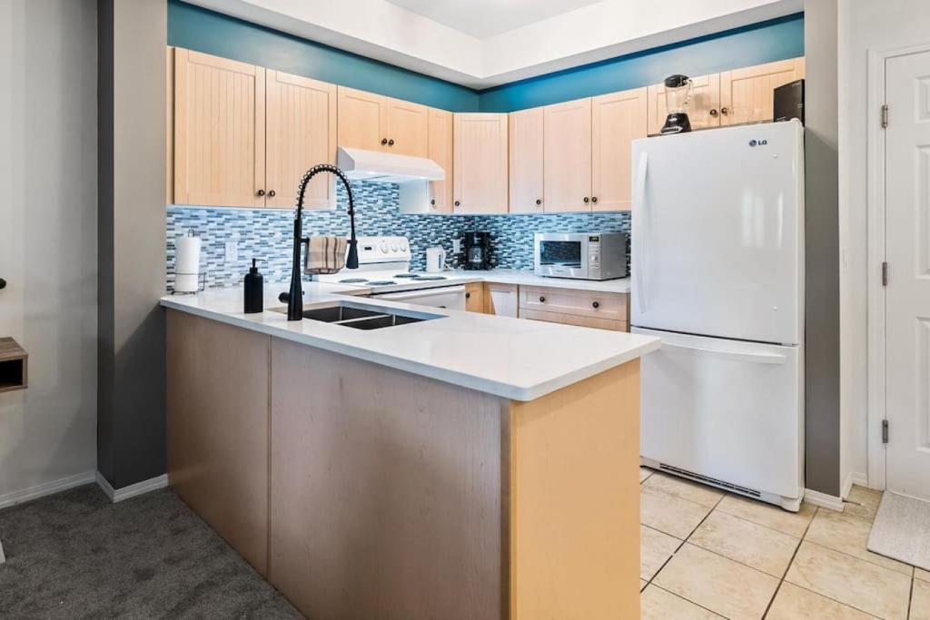 cocina con fregadero y nevera en Gorgeous Condo, Perfect Okanagan Getaway 1207 en Kelowna