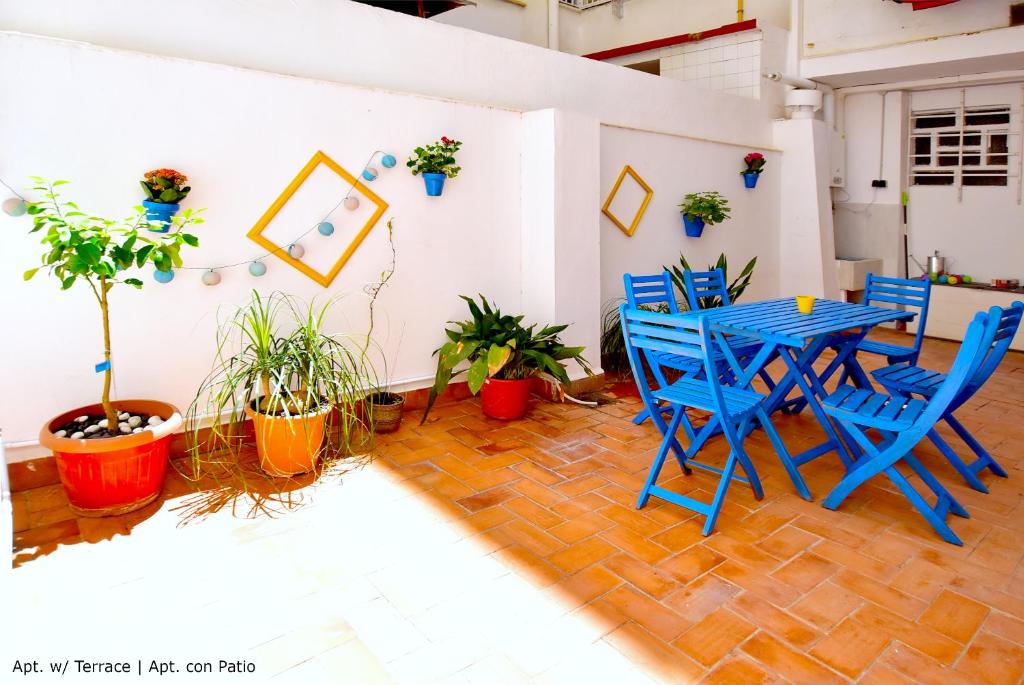 una mesa azul y sillas en una habitación con plantas en Emma Apartment Central, en Valencia