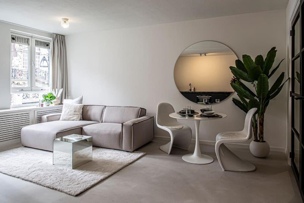 een woonkamer met een bank, een tafel en een spiegel bij Cloud Nine - romantic & design app in city center! in Dordrecht