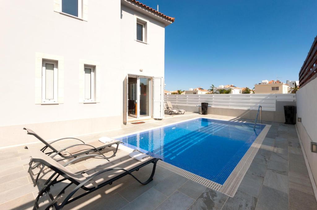 a swimming pool in the backyard of a house at Molly's Villa in Protaras