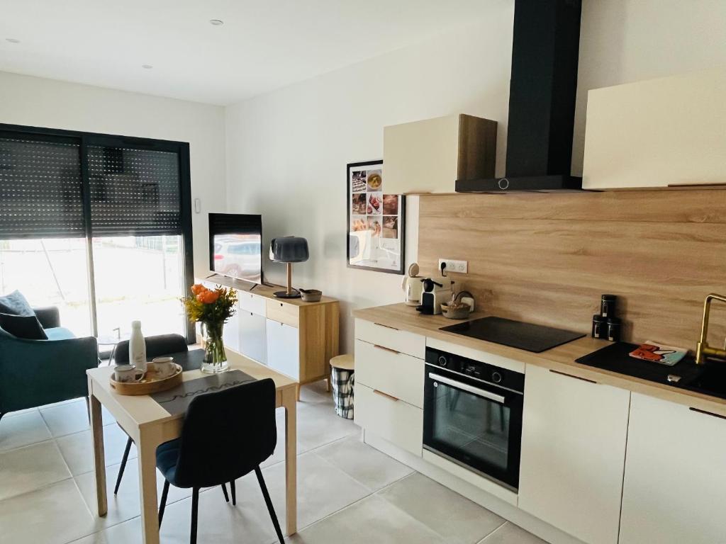 a kitchen with a table and a stove top oven at Appartement centre de Roanne 38m2 in Roanne