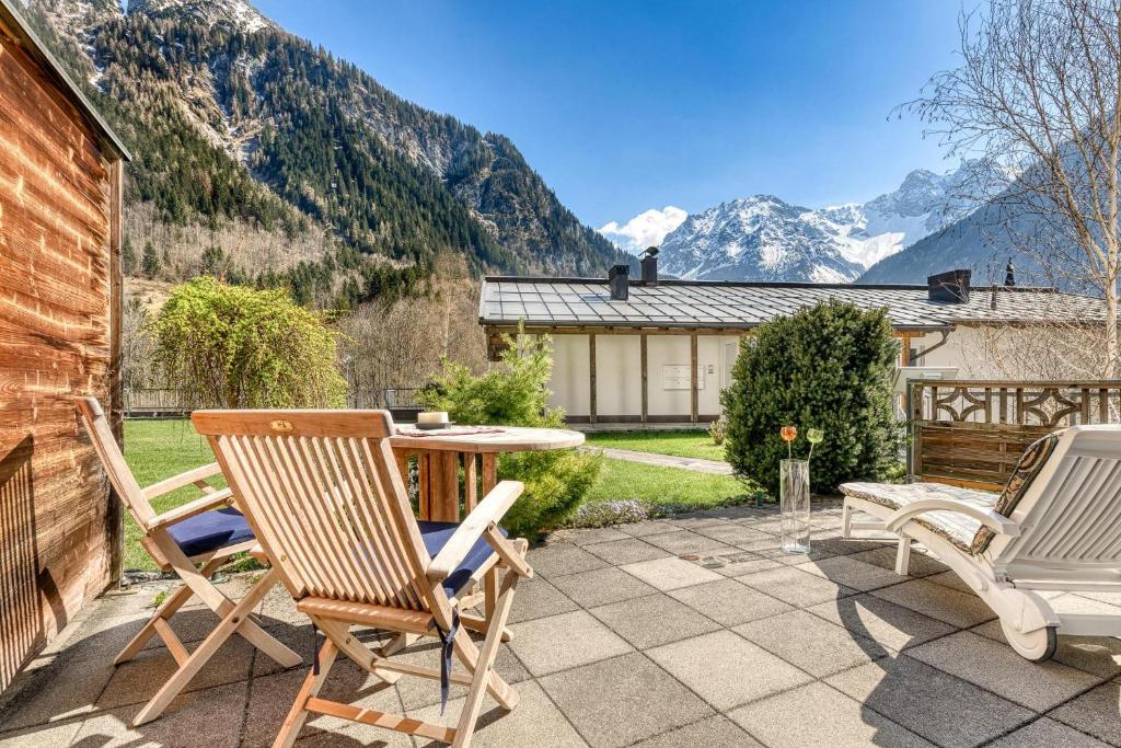 d'une terrasse avec deux chaises et une table avec des montagnes en arrière-plan. dans l'établissement Residenz Colrosa - Ferienwohnung Beck, à Brand