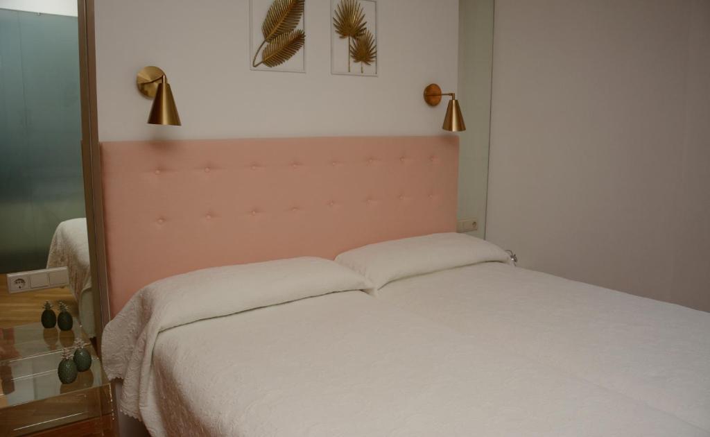 a bedroom with a white bed with two pillows at La Placita de Ana en Pontevedra centro in Pontevedra