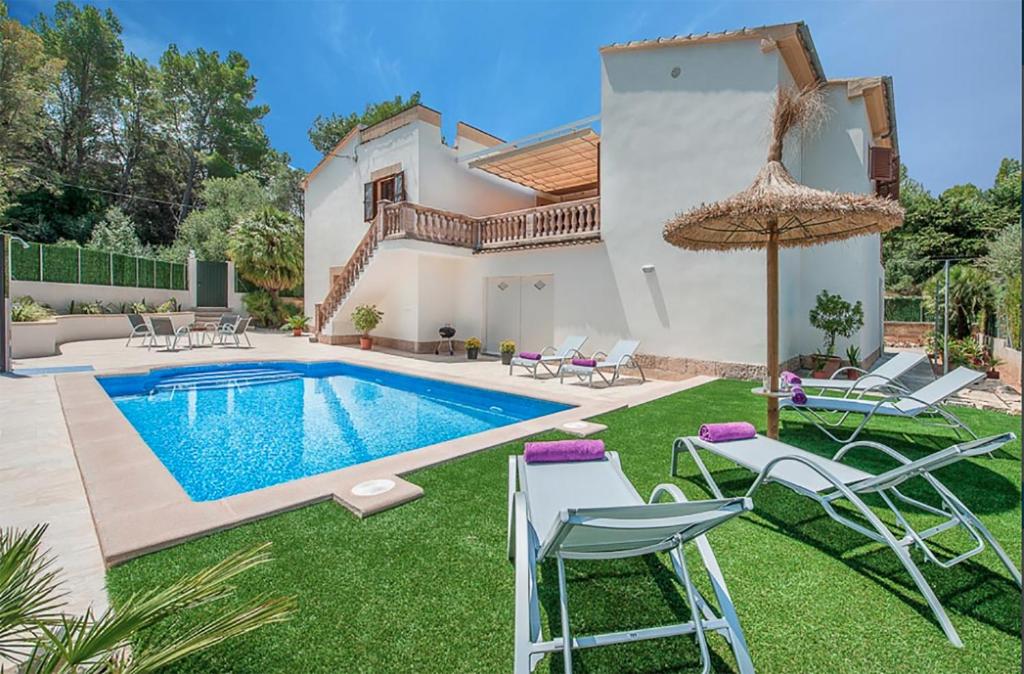 a villa with a swimming pool and patio furniture at Tacaritx de Bonaire, with pool and garden in Alcudia