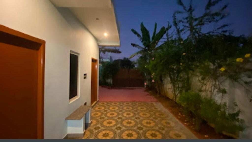 einen Flur eines weißen Gebäudes mit Fußweg in der Unterkunft Family Guest House Pondicherry in Vānūr